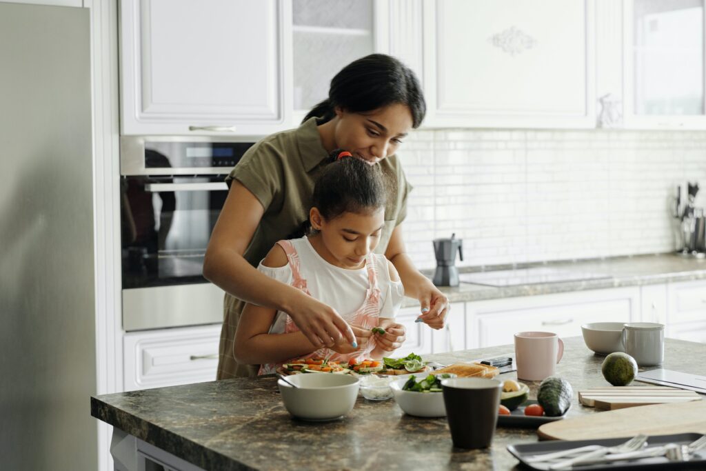 New mom prepares avocado toast for breakfast with a young child.